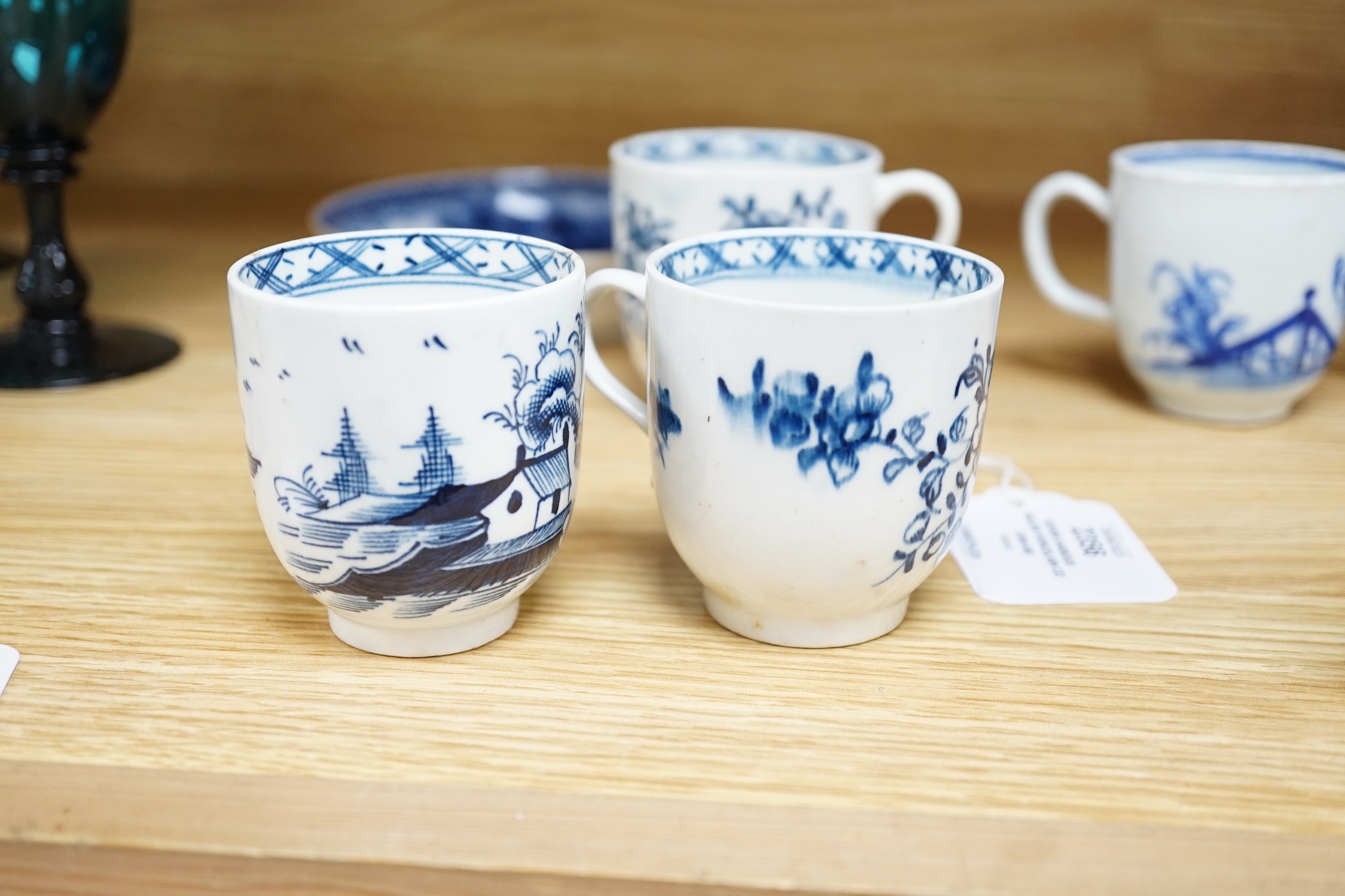 Seven various English porcelain coffee cups, including two Bristol enamelled with green floral sprays, two Bow painted in underglaze blue with a bird in a Chinese garden, and three Worcester/Bow in underglaze blue.